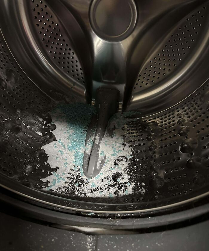 Laundry detergent powder spilled inside washing machine drum, a hilarious example of clueless partners' mistakes.