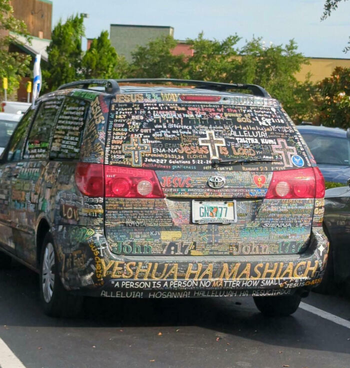 Minivan covered in detailed religious text and artwork, showcasing one of the most outrageous car mods visible.
