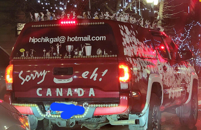 Red truck covered with numerous figurines and decals showing an outrageous car mod that took customization way too far.