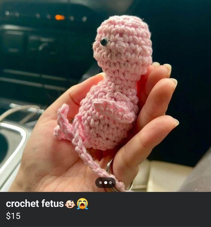 Hand holding a small pink crochet fetus craft, an example of horrible crafts that netizens shamed online.