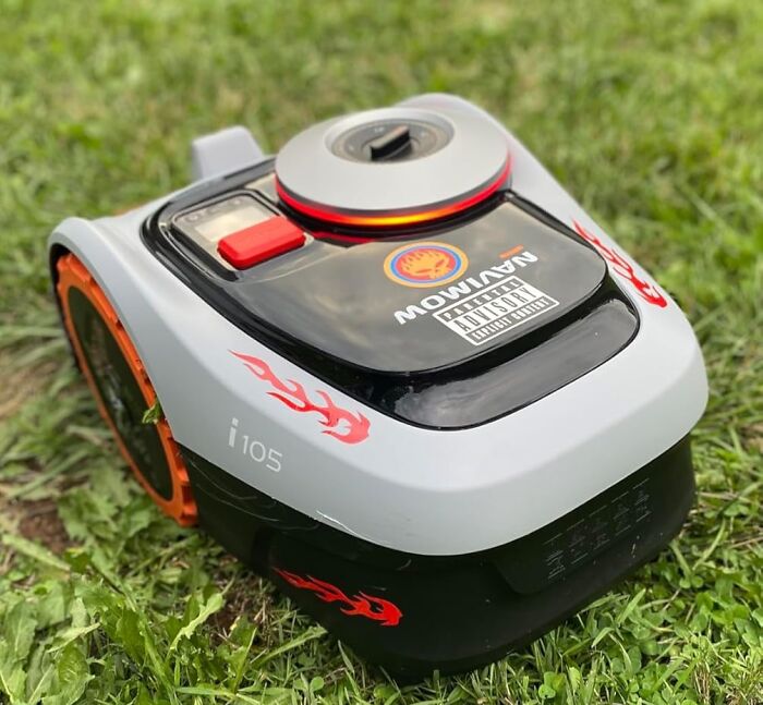 Robotic lawn mower with flame decals on grass, a top Prime Day treasure for smart yard care enthusiasts.