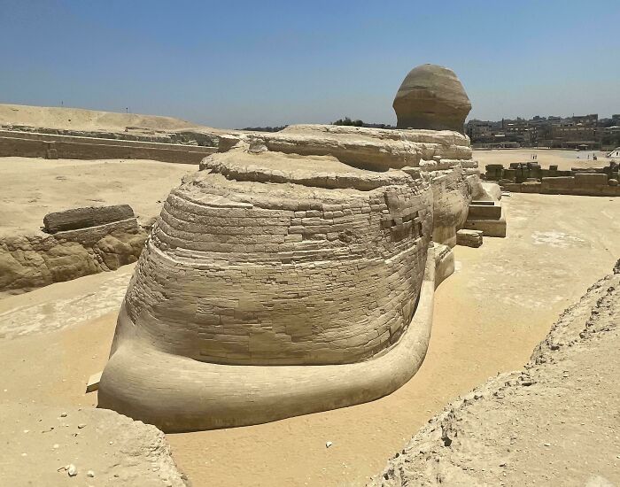 Ancient Egyptian Sphinx statue partially eroded in desert, showcasing mildly interesting historical architecture and stone detail.