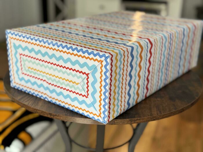 Rectangular box wrapped with colorful zigzag patterned paper, showcasing mildly interesting packaging details.