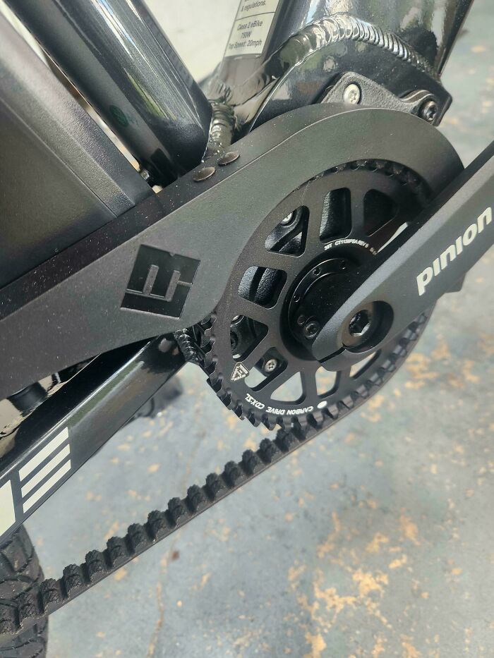 Close-up of a bike's mildly interesting carbon drive belt and pinion gear system on the frame.