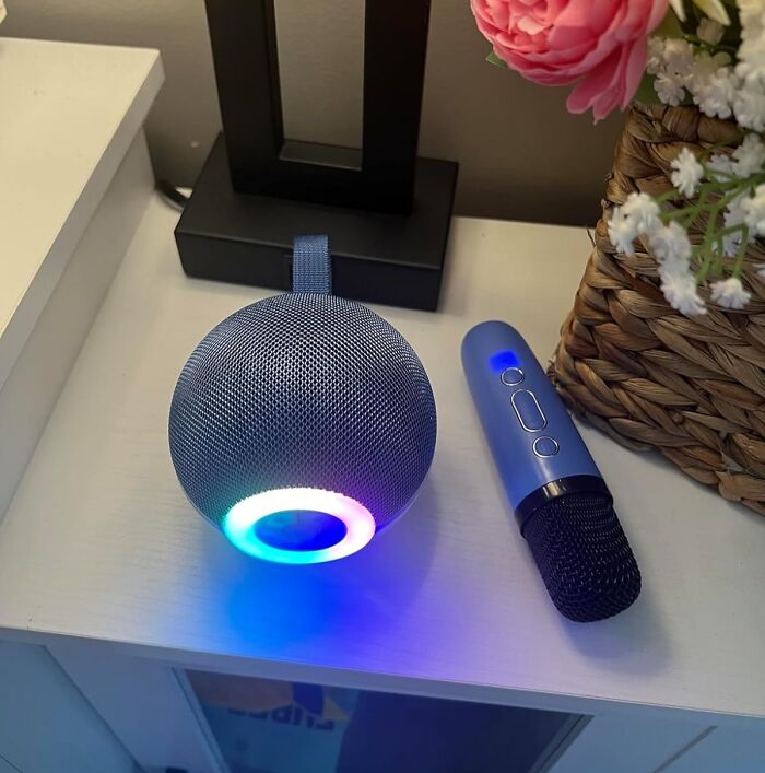 Smart speaker with color LED light and wireless microphone on a white table, showcasing Prime Day treasures.