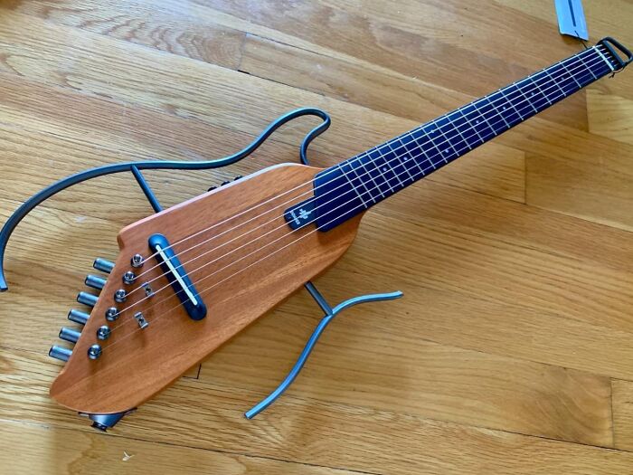 Electric travel guitar with wooden body and blue fretboard, featured among Prime Day treasures for unique gifts.