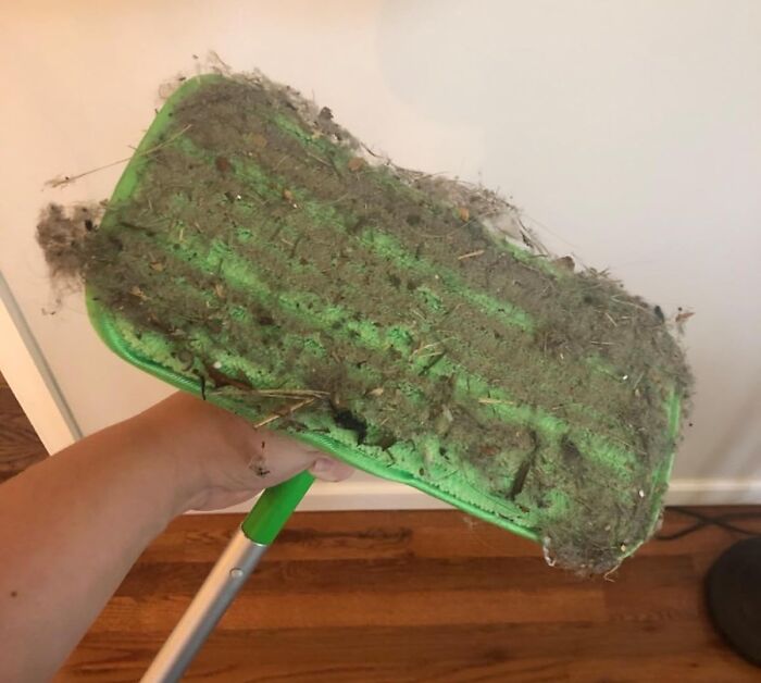 Green cleaning mop pad covered in dust and dirt, demonstrating effective cleaning finds for spotless grout line care.