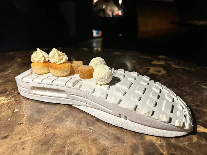 Unholy meals served creatively with desserts placed on a white sneaker sole for an unexpected food presentation.