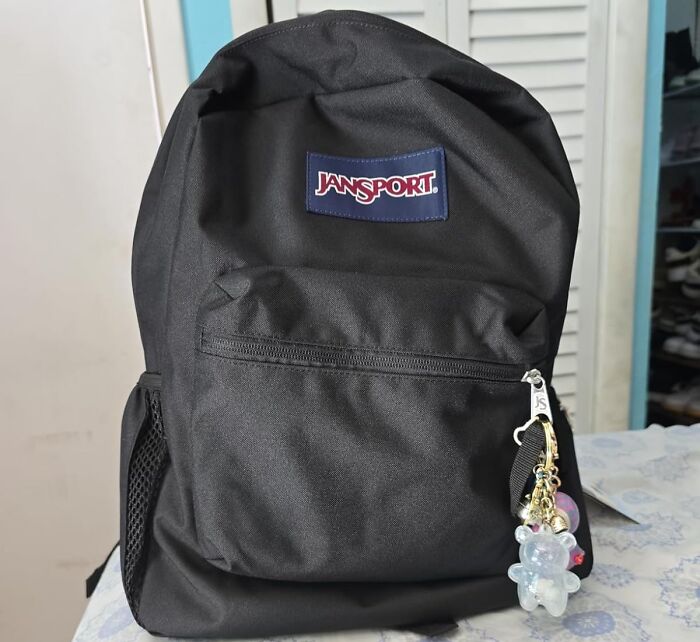 Black Jansport backpack with keychain on zipper, ready for back-to-school deals and syllabus preparation.