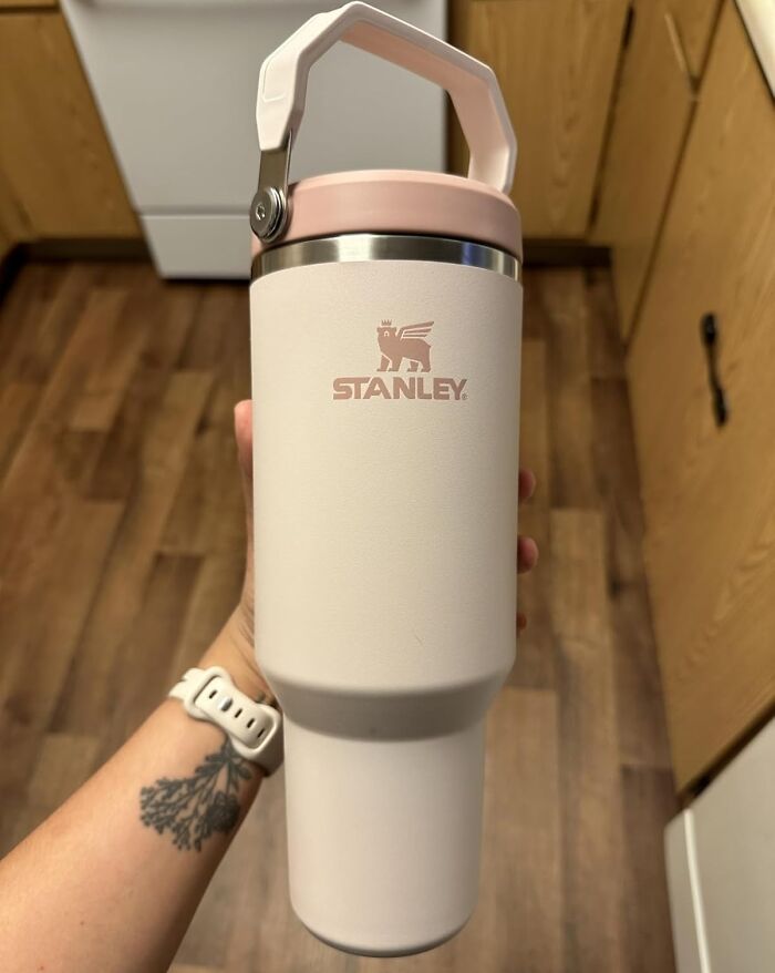 Stanley insulated tumbler held by a hand with a tattoo and white watch, perfect for back-to-school deals on Prime Day.