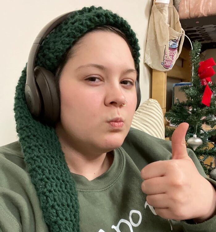Person wearing headphones and a green scarf giving a thumbs up, suggesting excitement for back-to-school deals on Prime Day.