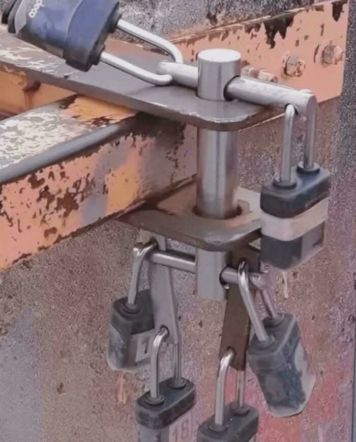 Multiple padlocks securing a metal latch in a creative redneck engineering style for added security.