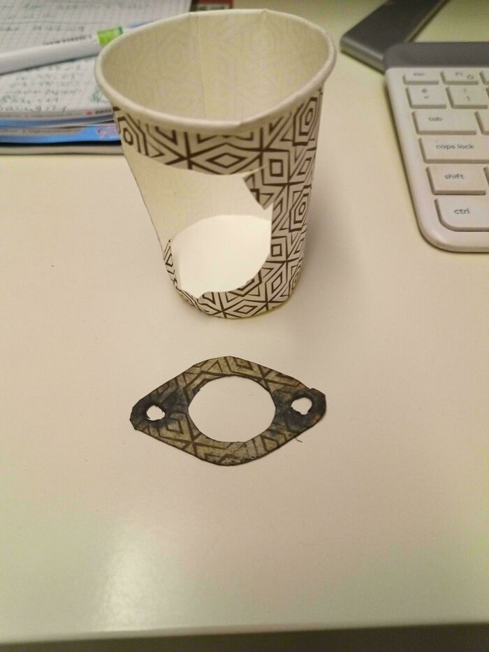 Paper cup with a cut-out section and a makeshift gasket made from the cup, showing redneck engineering creativity.