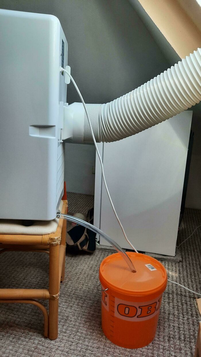 Improvised redneck engineering cooler drainage system using bucket and flexible hose for creative MacGyvering solution.