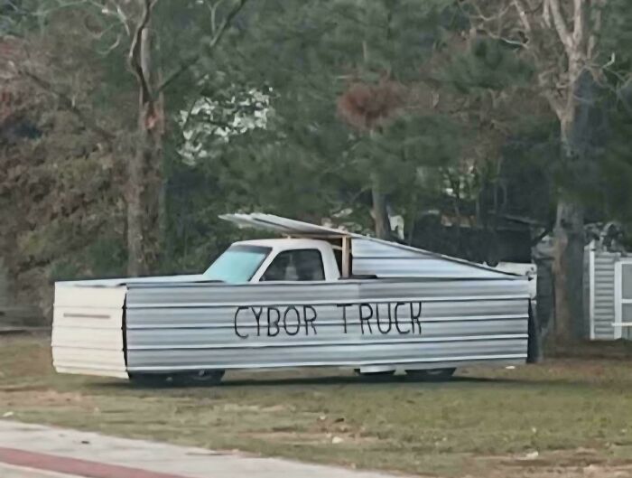 Truck creatively covered in metal panels labeled Cybor Truck, showcasing redneck engineering and inventive MacGyvering skills.