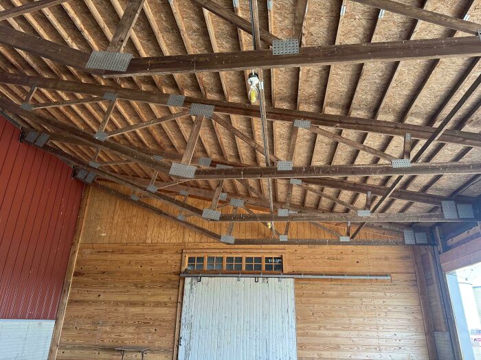Wooden barn interior showing redneck engineering with creative macgyvering using metal braces and beams.