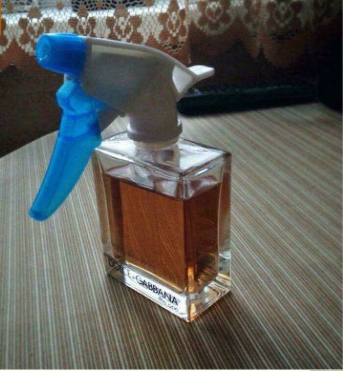 Clear cologne bottle with a blue spray nozzle attached, demonstrating redneck engineering creativity and MacGyvering skills.