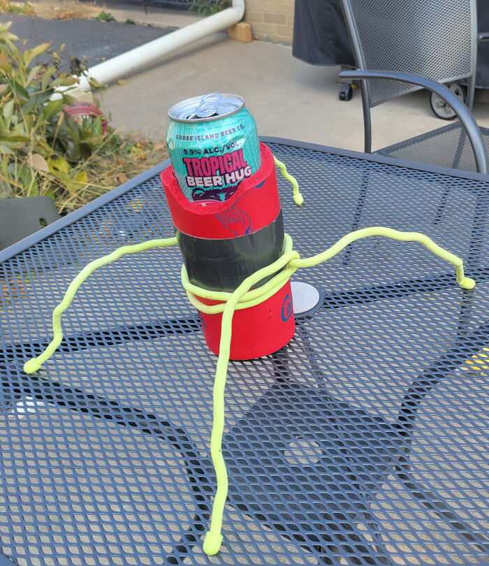 Can cooler secured with duct tape and flexible rods on metal patio table showing redneck engineering creativity.