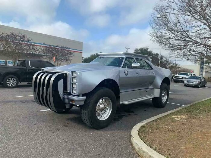 Custom off-road vehicle with oversized tires and a large grill guard, showcasing redneck engineering creativity and macgyvering.