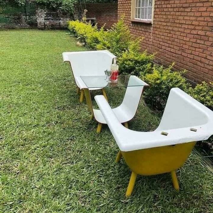 Outdoor seating made from repurposed bathtubs with a glass table, showcasing creative redneck engineering and MacGyvering.