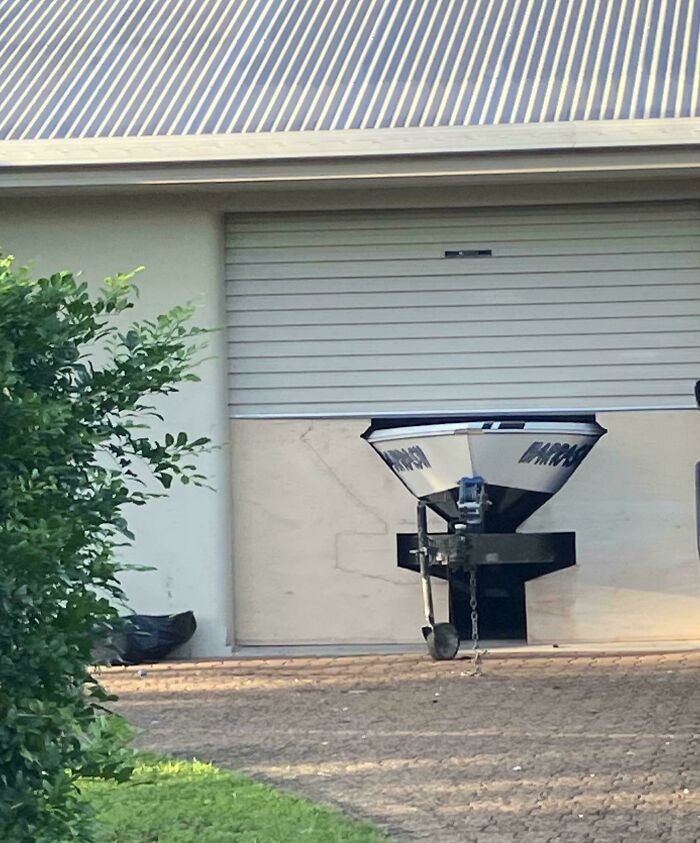 Metal hopper attached to a building in an example of redneck engineering and creative MacGyvering outdoors.