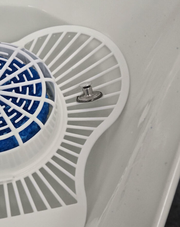 Small metal push pin stuck in a kitchen sink strainer, an example of an epic work fail at home.