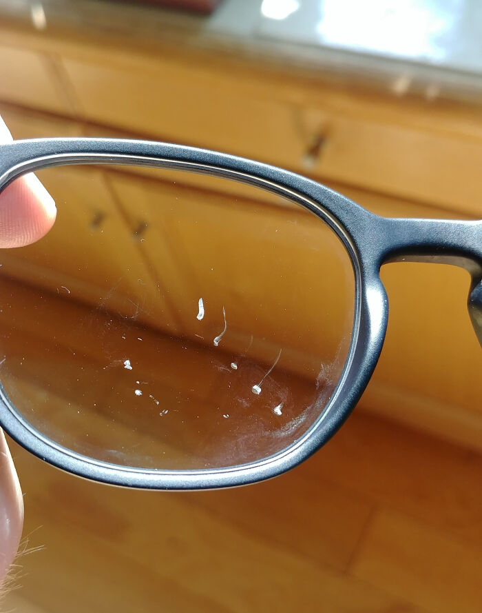 Close-up of sunglasses with scratched lenses illustrating an epic work fail from accidental damage at a workspace.