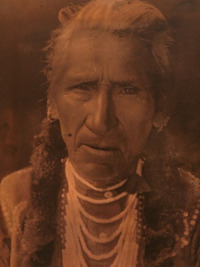 Elder Native American man wearing traditional jewelry in a powerful Edward S. Curtis photo preserving history.