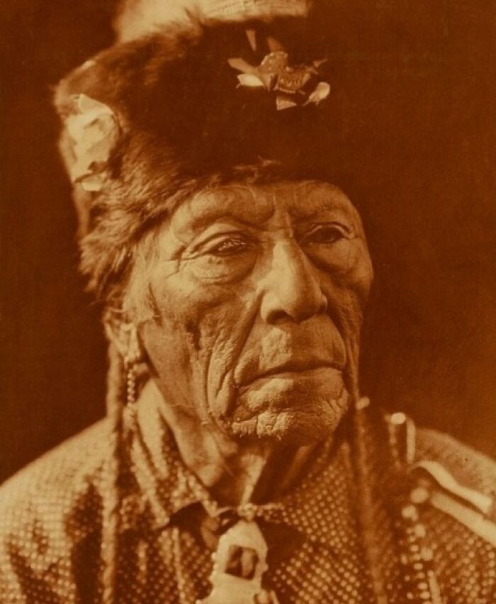 Native American elder wearing traditional attire in a powerful Edward S. Curtis photo preserving history.