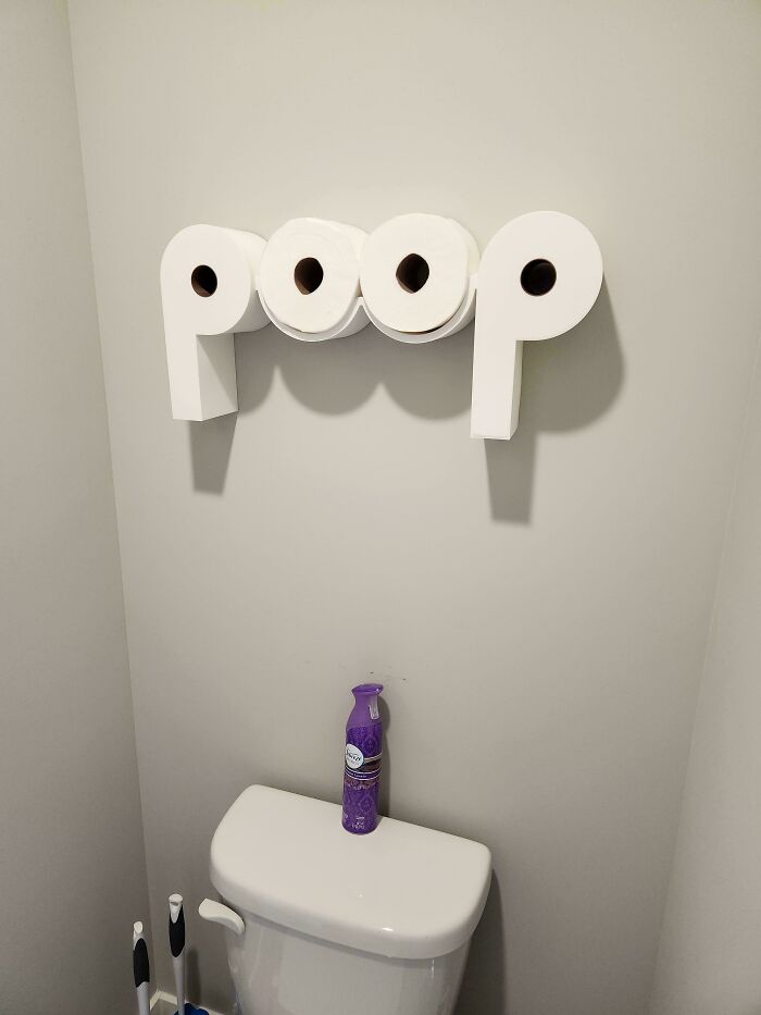 Creative living space revamp featuring toilet paper rolls arranged in a playful design above a bathroom toilet.