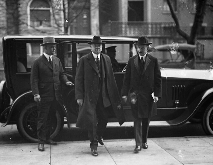 Three men in 1920s suits and hats standing next to a vintage car in Washington, D.C., historical photo.