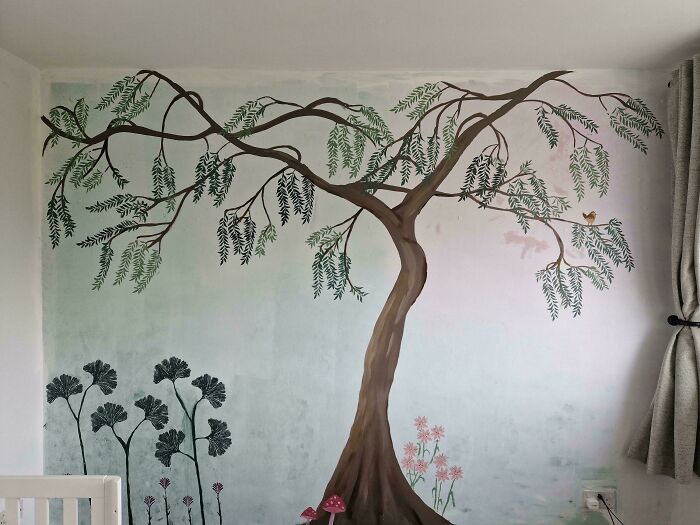 Wall mural with a large tree and plants, a creative living space revamp shared online for home decoration inspiration.
