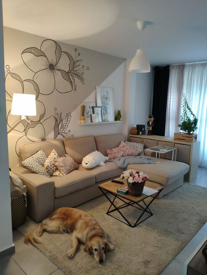 Cozy living space revamped with floral wall art, beige sofa, decorative pillows, and a golden retriever resting on a rug.
