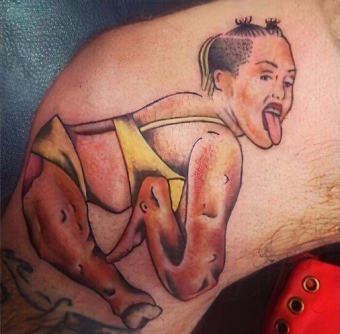 Tattoo of a distorted human figure with uneven limbs and a tongue sticking out, showcasing an abysmally bad tattoo.