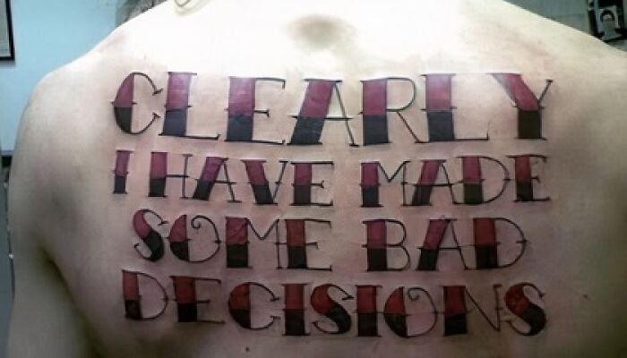 Tattoo on back with large lettering stating clearly I have made some bad decisions, example of bad tattoos.