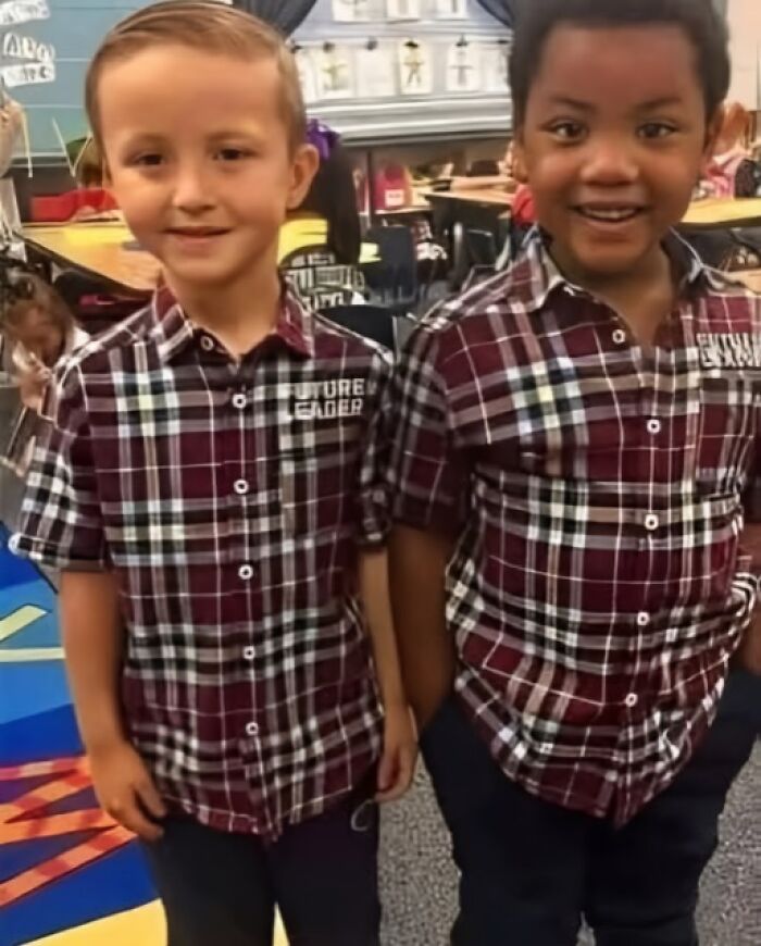 Two young boys smiling and holding hands in a classroom, showcasing a wholesome moment in the wonderful world.