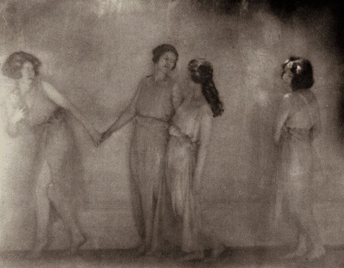 Faded old photo of four women in flowing dresses capturing the beauty of women from the 1900s in soft focus.