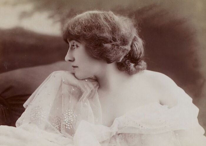 Vintage sepia photo of a woman from the 1900s wearing a sheer dress, showcasing the beauty of women in old photos.