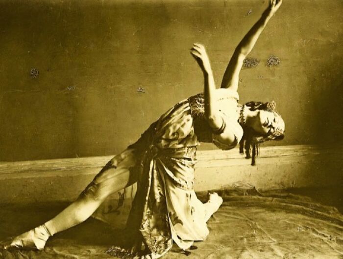 Vintage sepia photo of a woman from the 1900s gracefully posing, showcasing the beauty of women in old photos.