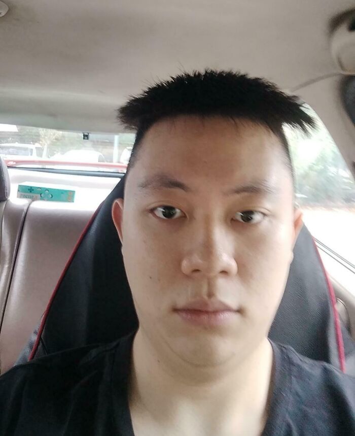 Young man with a disappointing haircut after a salon visit, showing an unexpected glow-up breakdown inside a car.