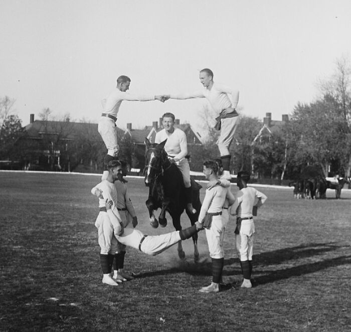 Vintage 1920s Washington DC photo of men performing gymnastic stunts on horseback in a grassy field.