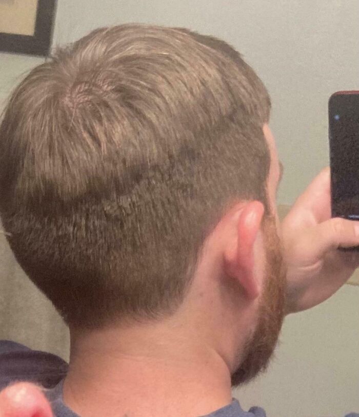 Man taking a selfie showing a poorly done haircut after a salon visit, highlighting a glow-up gone wrong.