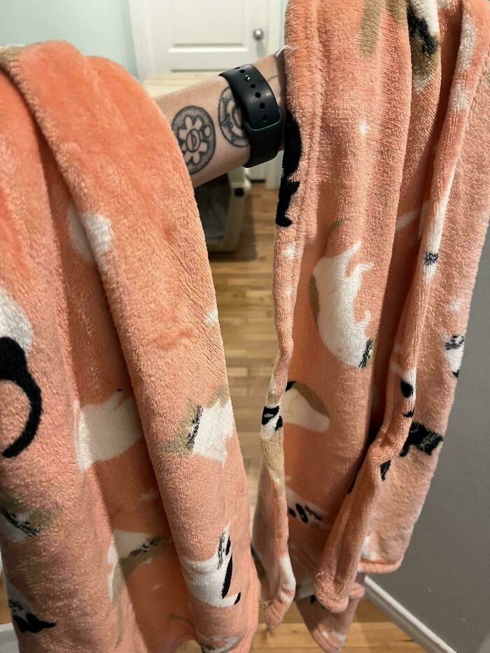 Person holding a glitch in the matrix with a peach-colored fuzzy blanket featuring white and black cat patterns.