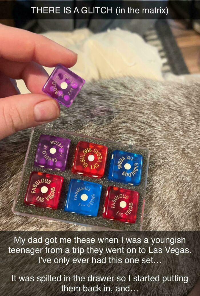 Close-up of a hand holding a purple dice from a set of Las Vegas dice showing a real-life glitch in the matrix.
