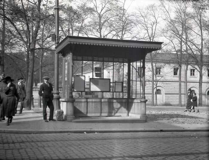Black and white historical photographs showing a street scene with people and a kiosk from 100 years ago.