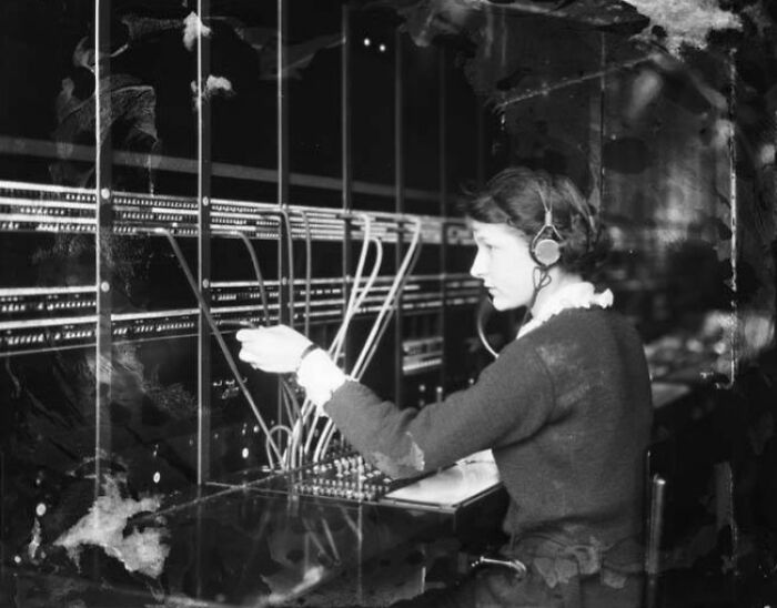 Young woman operating an early telephone switchboard in a rare historical photograph not found in textbooks.