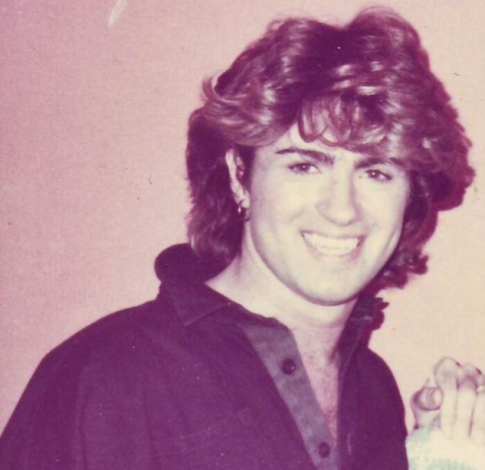 Young celebrity with voluminous hair smiling in vintage photo, representing misunderstood celebrities in their time.