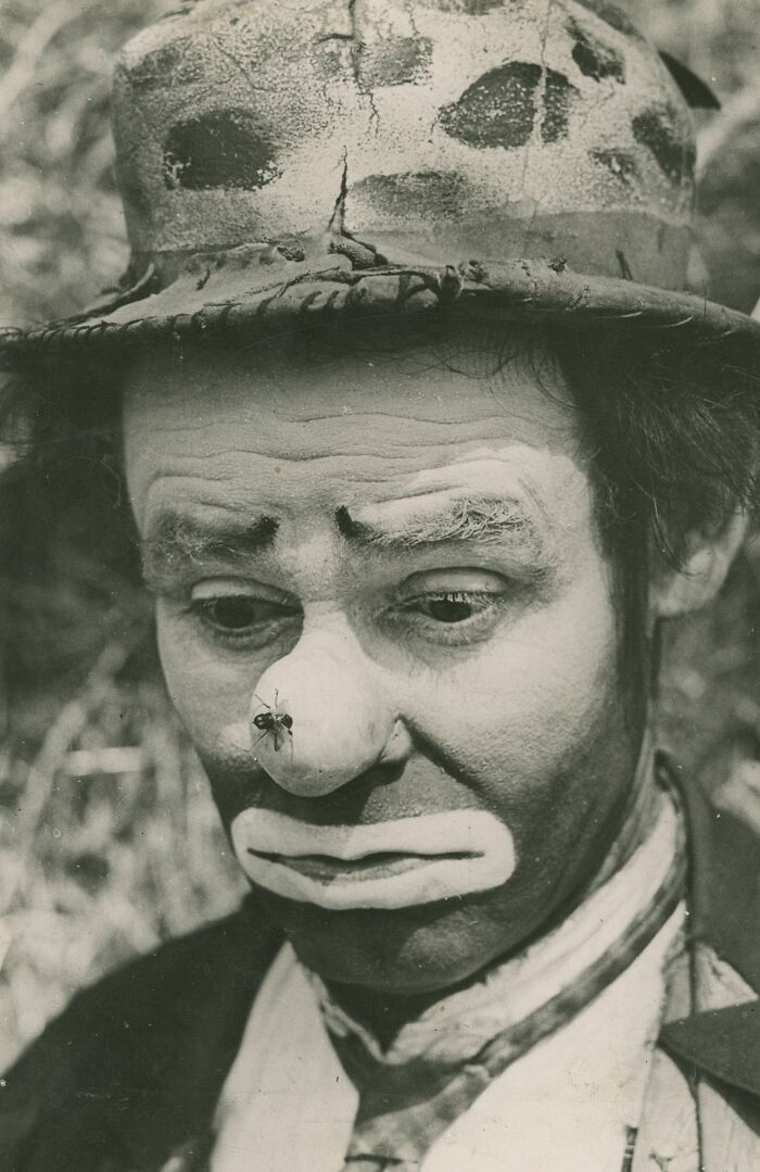 Black and white rare historical photograph of a sad clown with a fly on his nose, capturing an unusual moment.