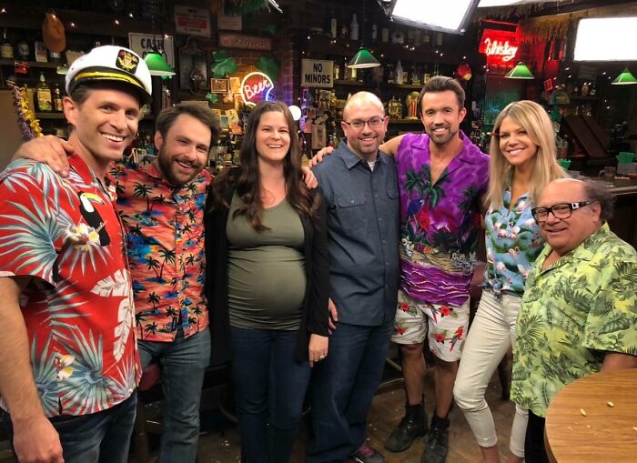 Group of people smiling in a bar setting, showcasing a moment of unbelievable luck and joyful connection.