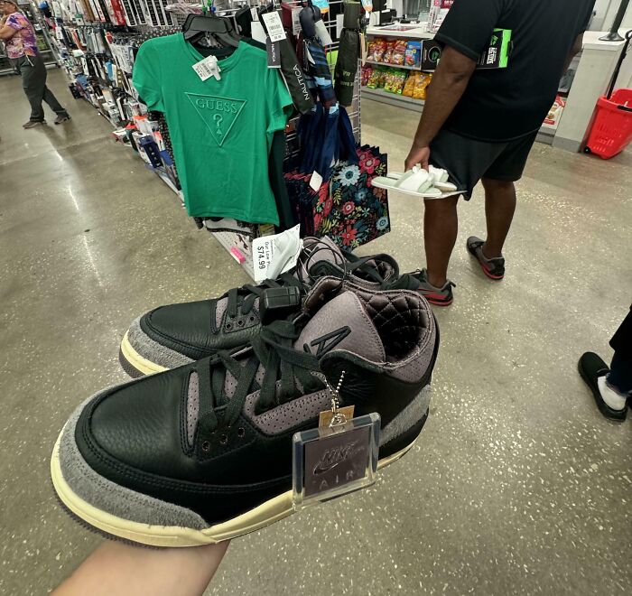 Rare Nike Air sneakers held by a person in a store, showcasing unbelievable luck with a hidden price tag.
